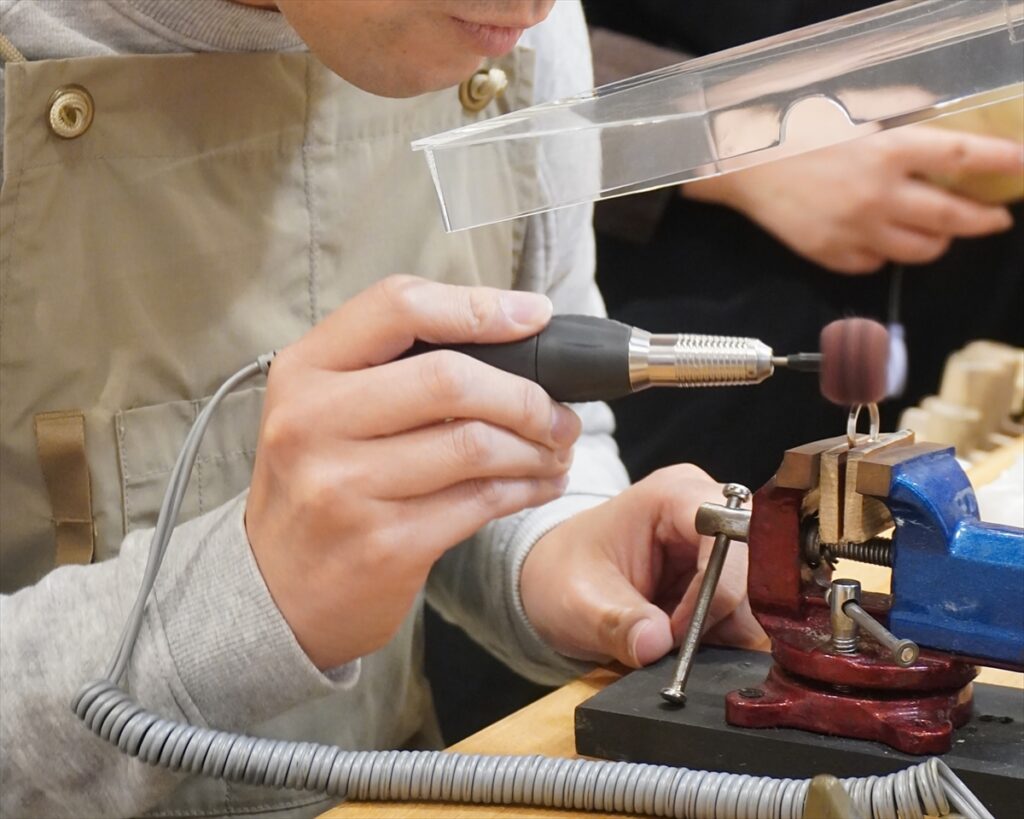 回転する専用の器具で結婚指輪の艶消し加工