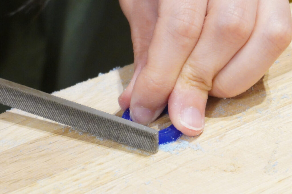 細身デザインのワックスリングを慎重に削る制作中の様子