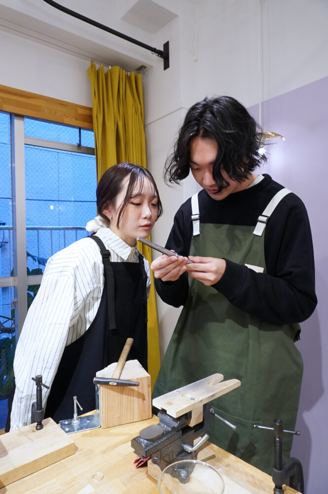 手作り結婚指輪の槌目模様の確認をしているカップル