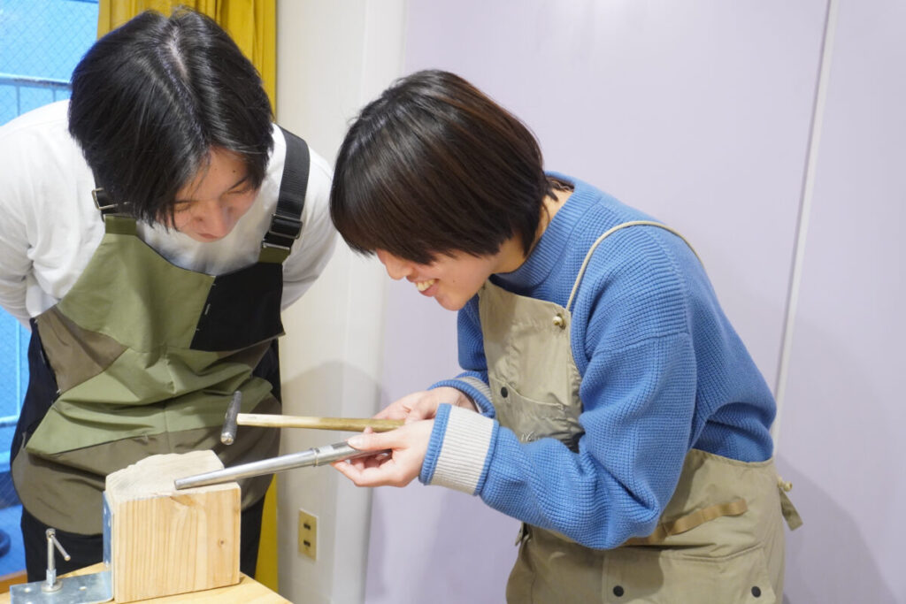 お互いの結婚指輪にハンマーで模様をつけている北九州から来店のカップル