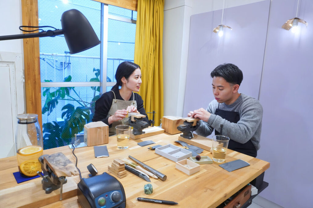 福岡のアトリエで手作り結婚指輪を検討するカップルが制作前に説明を受けている様子