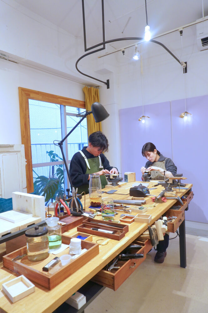 手作り結婚指輪を制作中のカップル 真剣に作業する様子