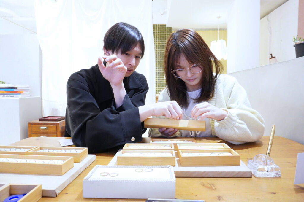 結婚指輪のデザインを比較しながら選ぶカップルの様子